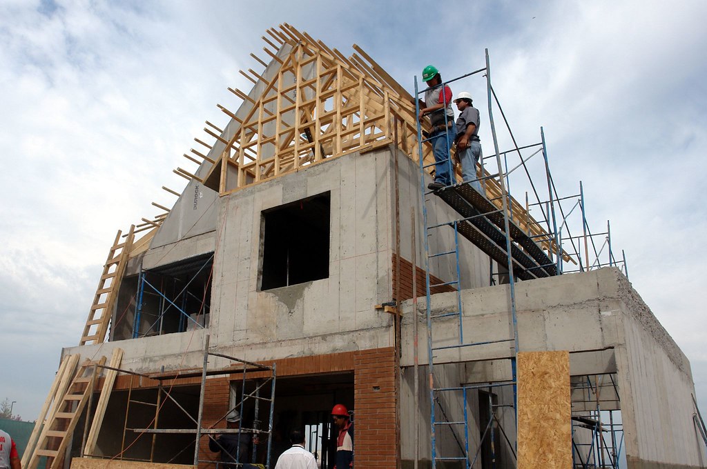 Maçons montant les murs en parpaing d'une maison Maisons Vireloup